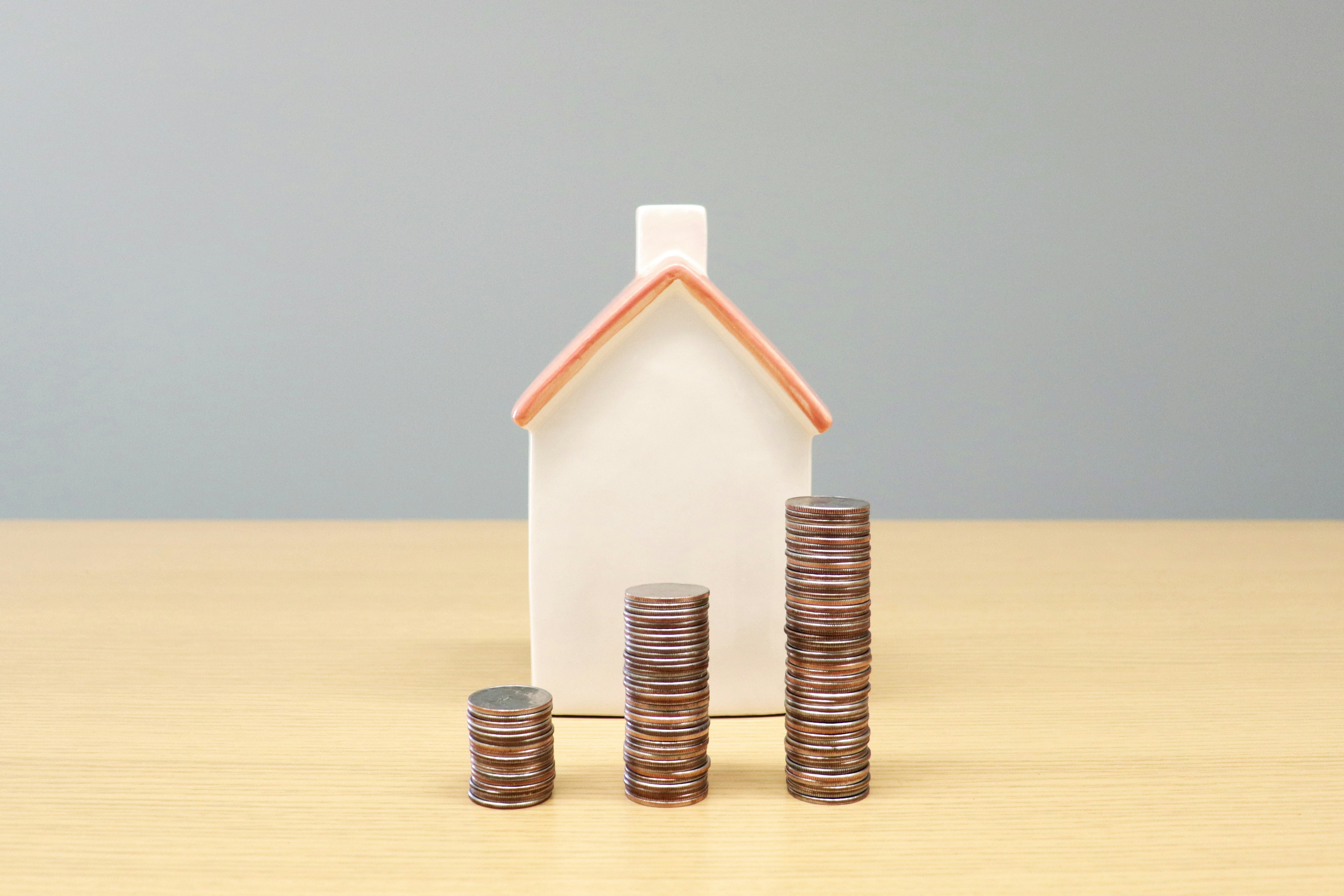 stack of coins in front of a home